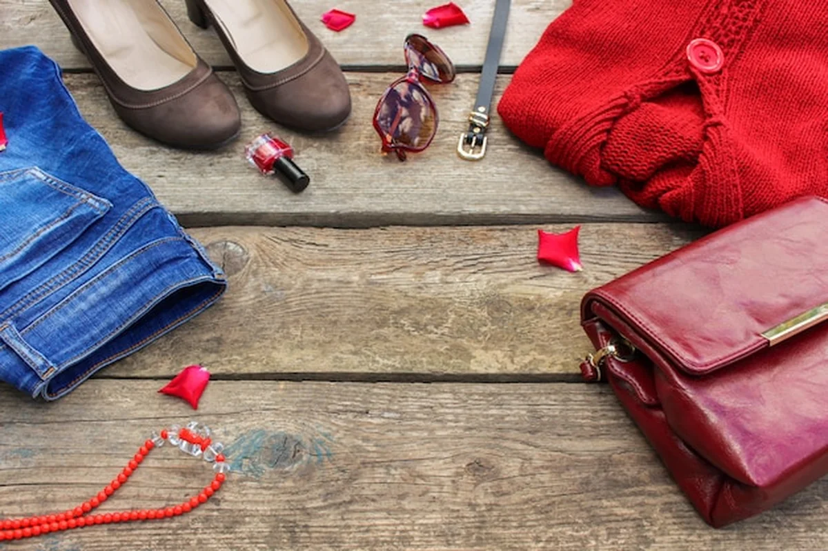 Jesienna odzież i akcesoria damskie na drewnianym tle