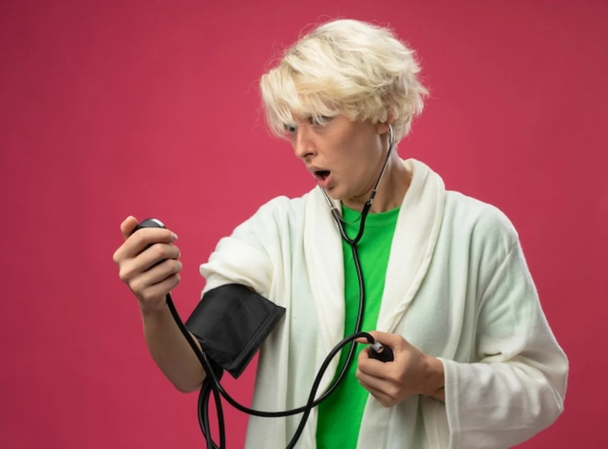 Napięta kobieta z krótkimi włosami i stetoskopem mierzy ciśnienie krwi