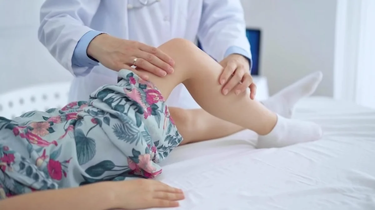 Lekarz i pacjent badające kolano dziewcząt w klinice medycznej