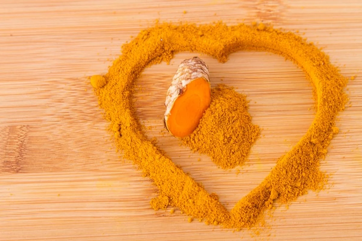 Kurkuma proszek i korzenie na drewnianym tle