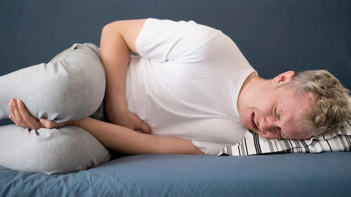 Mężczyzna leżący w łóżku z bólami jąder