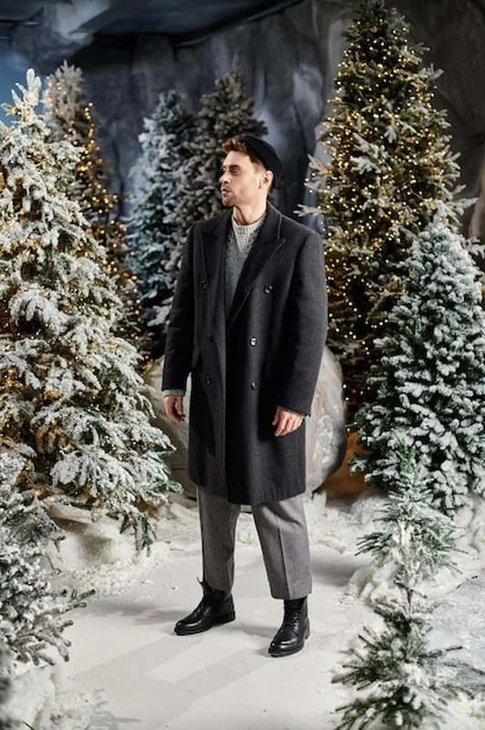 Mężczyzna w eleganckim garniturze w zimowym krajobrazie świątecznym