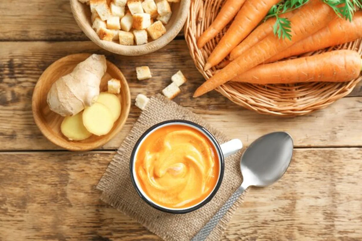Zupa marchewkowa z imbirem na drewnianym stole