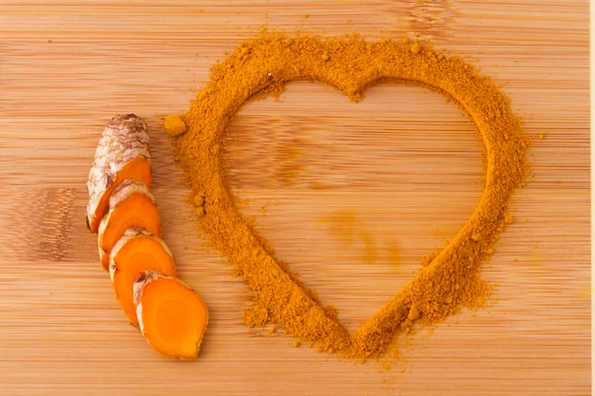 Kurkuma proszek i korzenie na drewnianym tle