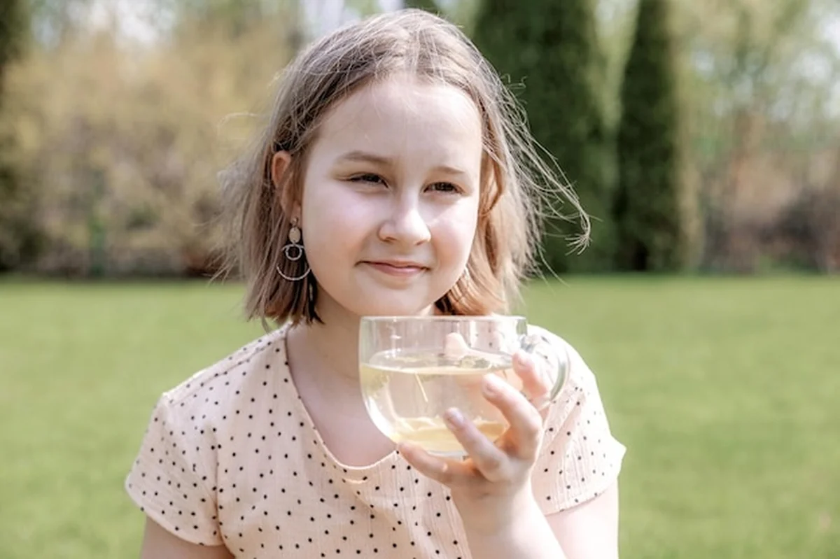 Piękna dziewczyna pije zieloną herbatę