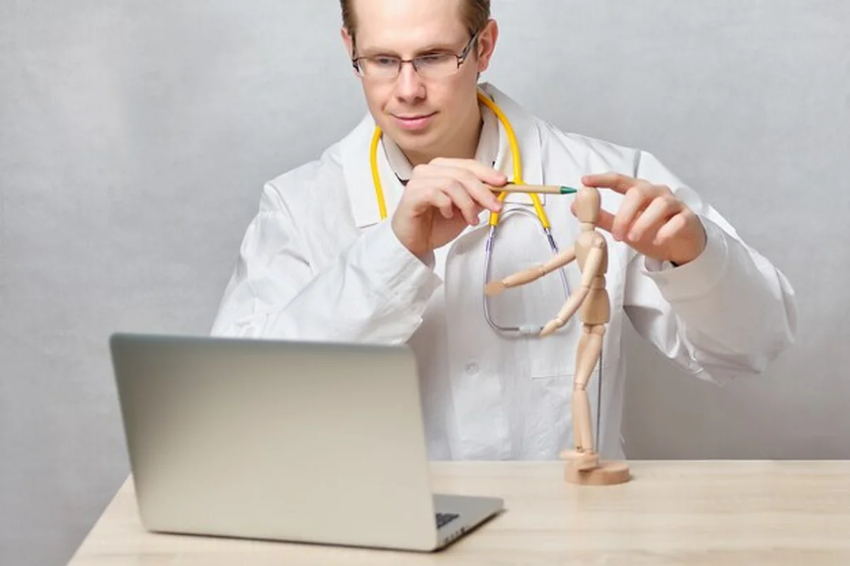 Lekarz prowadzi lekcję online z laptopem o leczeniu bólów głowy