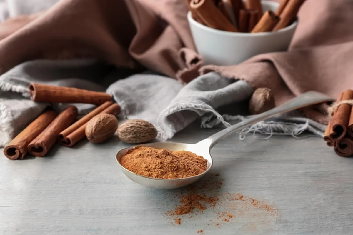 Metalowa chochla ze sproszkowanym cynamonem na szarym stole