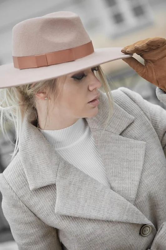 Blondynka w beżowym płaszczu, brązowej czapce i rękawiczkach