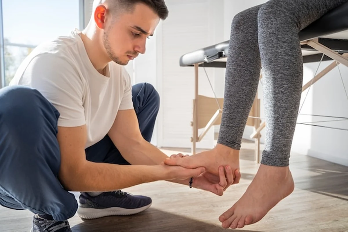 Mężczyzna masuje stopę pacjenta z bliska