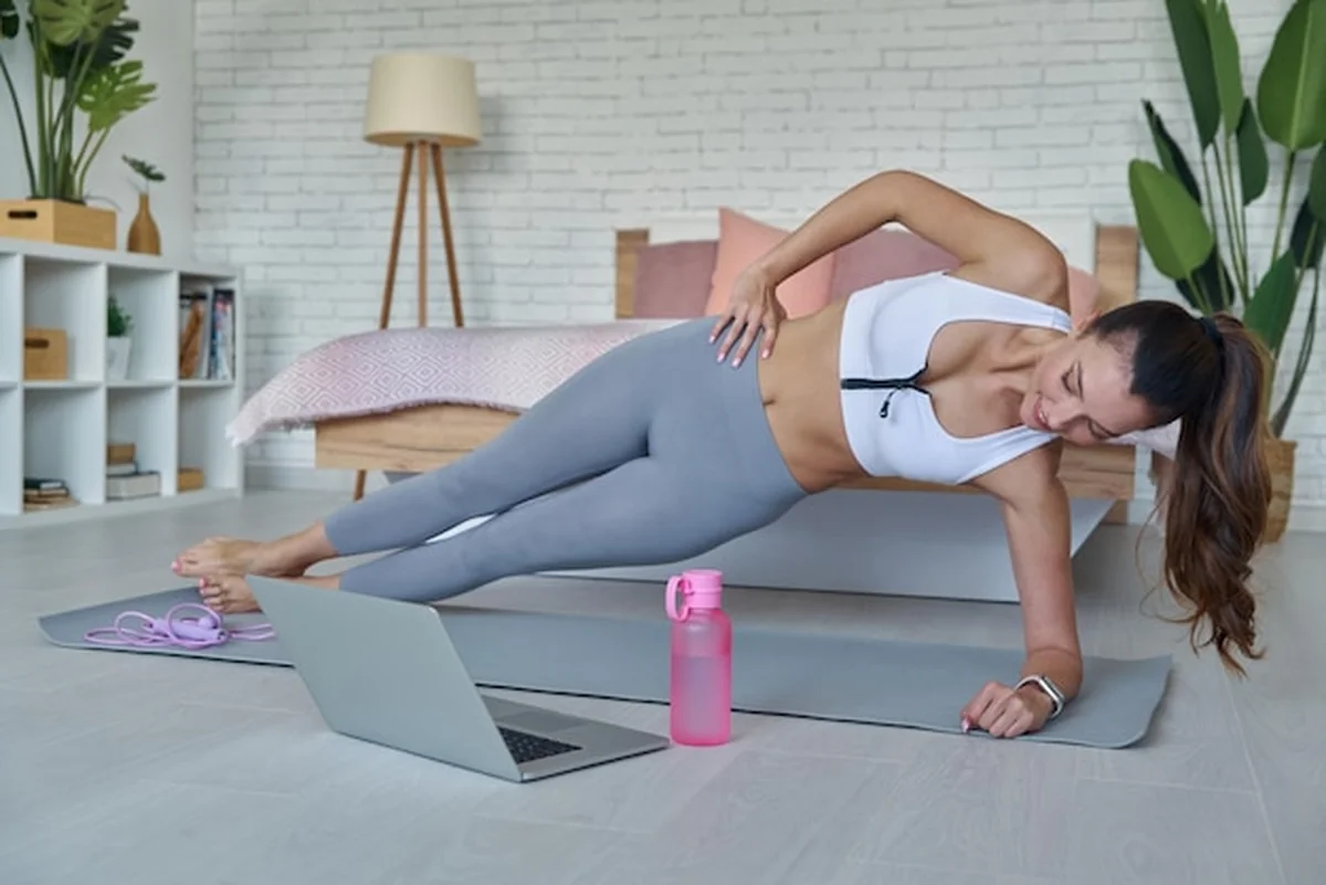 Kobieta wykonuje jogę z laptopem na kolanach
