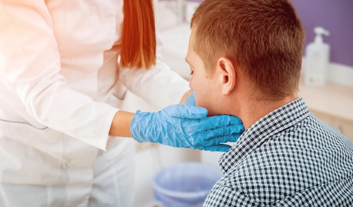 Otolaryngolog bada gardło mężczyzny