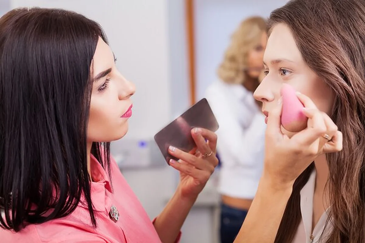 Młoda rudowłosa kobieta robi makijaż cieni do powiek