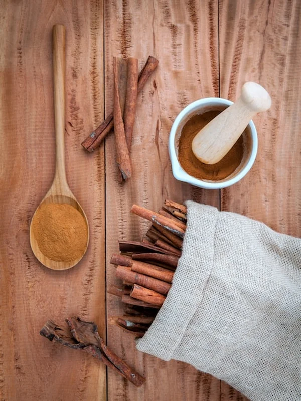 Skład cynamonowy kij i proszek na drewnianym tle