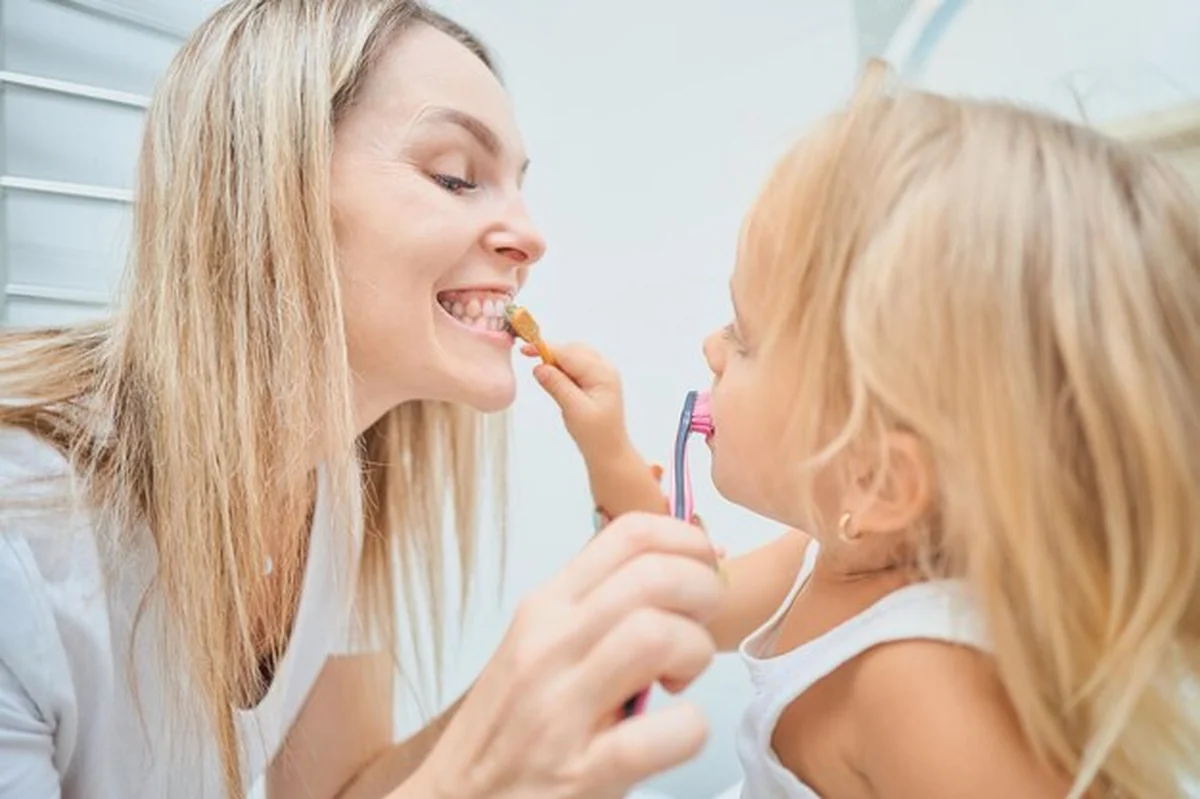 Kobieta i dziecko szczotkują sobie zęby