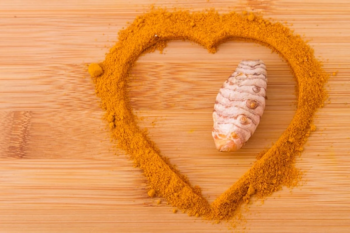 Kurkuma proszek i korzenie na drewnianym tle