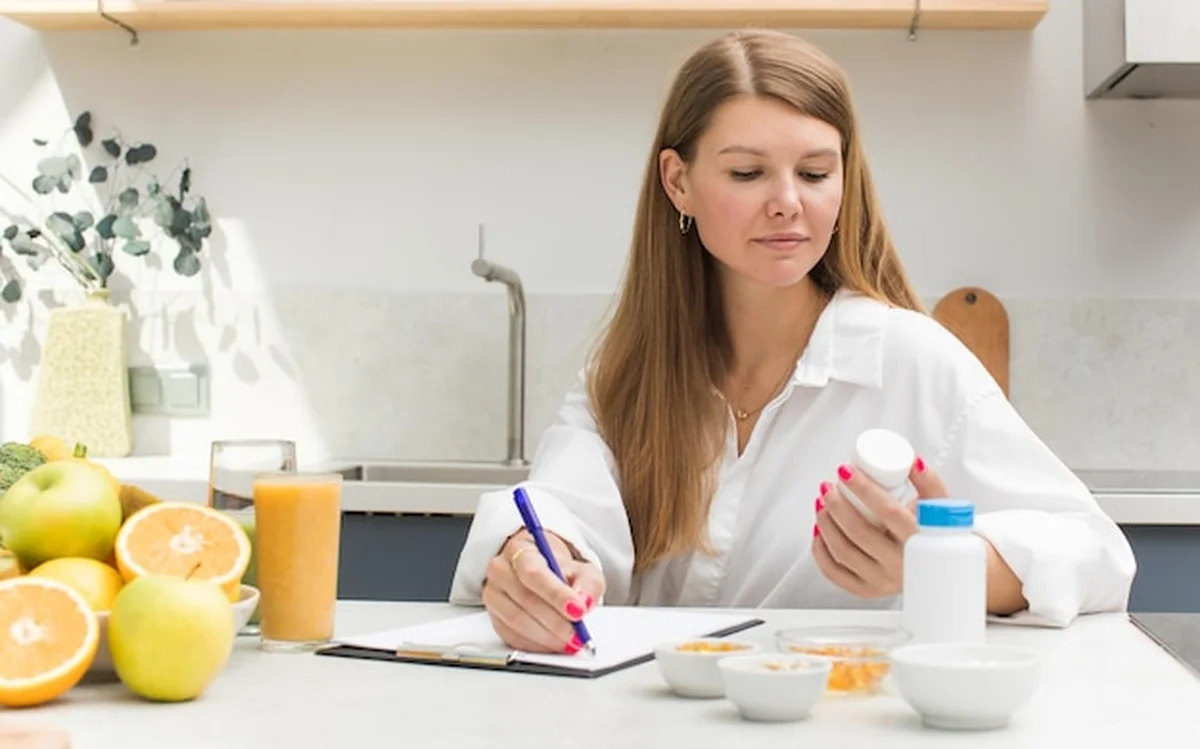 Dietetyk zapisuje suplementy i witaminy dla pacjenta